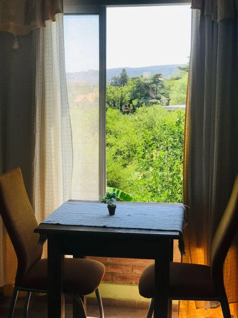 Mesa y ventana con vista a las sierras de Habitación Suite en Complejo Manakel